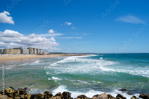 Wallpaper Mural Lissabon Strand von Costa da Caparica offers serene views of waves and vibrant beach activities on a sunny day in Portugal Torontodigital.ca