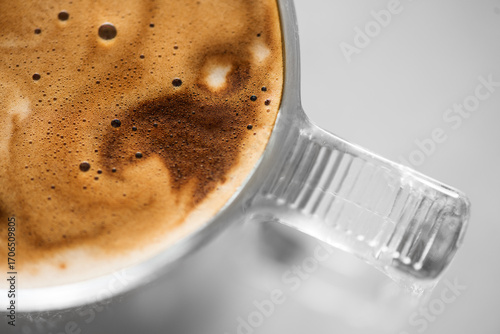 Coffee cup from above, Espresso foam texture, creamy coffee, rich, freshly brewed cup of hot latte. Top view of cappuccino milk foam closeup. Creamy coffee macro shot, on a grey table, top view 