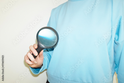 Hand holding magnifying glass with zooming lens with hard flashlight
