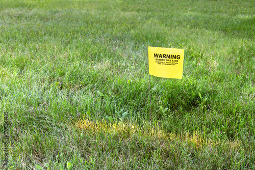 Gas line marker in the yard. Yellow utility flag placed in the yard of a house