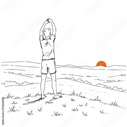 Man stretching while standing on grassy hill at sunset  
