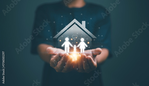 Family insurance concept. Businessman holding family and house icon. Parents and child symbol. Representing protection, financial security, health coverage and future stability. Life Insurance.