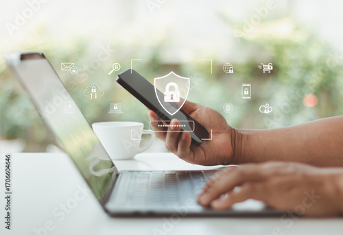 Cybersecurity concept with man using smartphone and laptop for secure login, two factor authentication, data protection and online privacy in digital technology network. Cyber security verification.