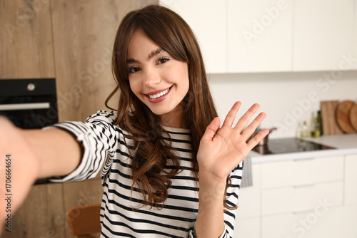 Young woman waving hand in ...