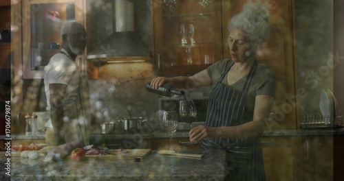 Wallpaper Mural Mature woman wearing apron pouring wine into glass on granite island in home kitchen, copy space Torontodigital.ca