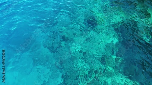 Wallpaper Mural A stunning top down drone video of a clear turquoise sea revealing the beautiful textures of the submerged rocks and sea floor the sunlight creates a shimmering effect on the water Torontodigital.ca