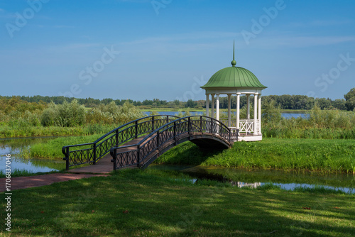 A gazebo with a bridge on the bank of the Volkhov River in the Novgorod Museum of Folk Wooden Architecture Vitoslavlitsy on a sunny summer day, Veliky Novgorod, Russia