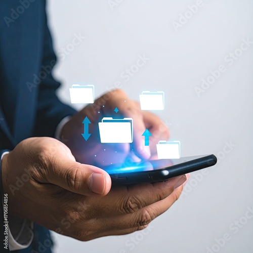 Businessperson touches smartphone screen with folder icons, implying file transfer