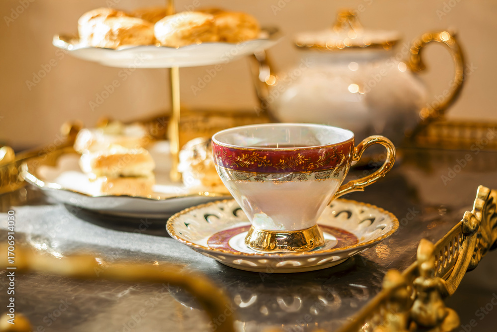 Fototapeta premium Ornate teacup and saucer at a luxurious blurred afternoon tea service