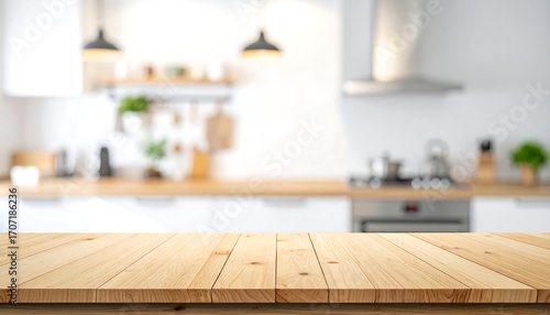 Empty wooden table top in the foreground with a blurred modern kitchen in the background, ideal for product placement or design mockups