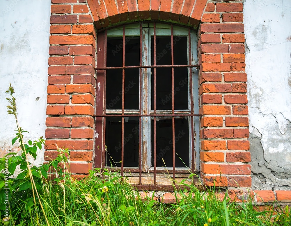 Obraz premium Aged brick building with barred window