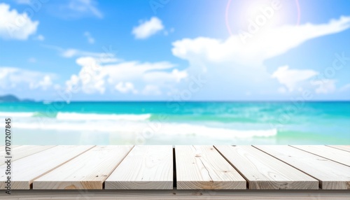 Bright sunny beach scene with turquoise water and white clouds, out of focus backdrop with a clear wooden surface in foreground