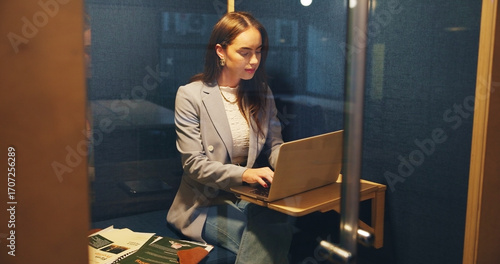 Booth, business and woman in office with laptop for online project, productivity and proposal. Creative, professional and worker on computer for privacy, coworking space and cubicle for research