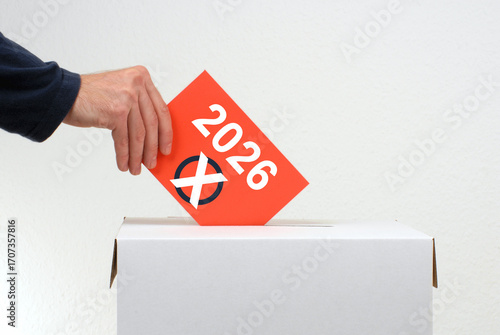 Wahl im Jahr 2026 - Hand wirft Stimmzettel in Wahlurne