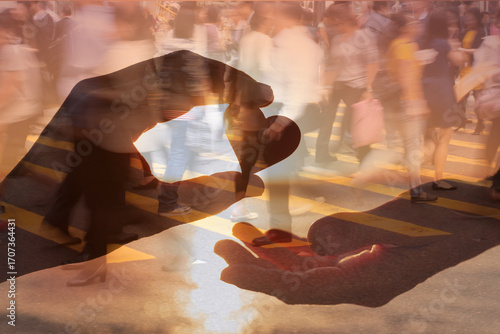 Man giving a heart to a woman. Love, friendship, kindness. Finding love and compassion in busy crowded city street background 