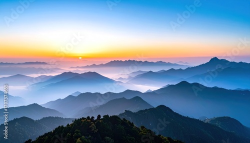 Serene vista featuring layers of mountains veiled in mist under a pastel sunrise sky, creating a peaceful and atmospheric landscape