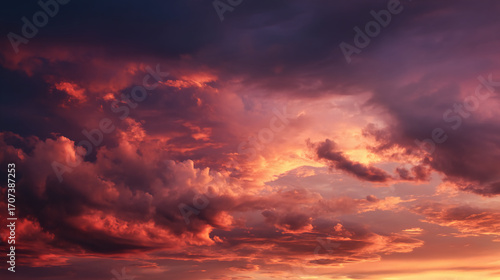 A breathtaking sunset with vibrant hues of orange, pink, and purple swirling through dramatic clouds, creating a stunning display of nature's beauty.