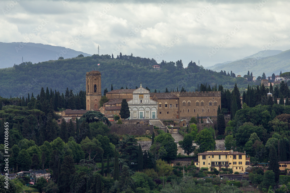 Obraz premium Panoramic view of San Miniato al Monte, a historical abbey in Florence, Italy, nestled on a hillside with surrounding cypress trees, perfect for travel, cultural, or architectural designs.