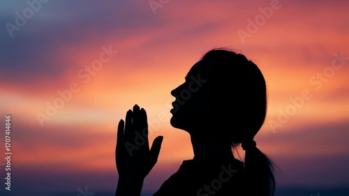 Silhouette praying at sunset sky