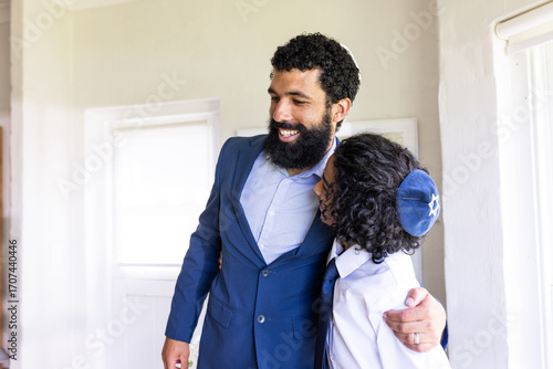 Father and son embracing joyfully during bar mitzvah at home