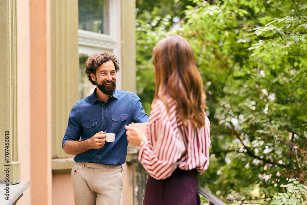 Fototapeta premium Man and Woman Enjoying Coffee Conversation on Terrace Outdoors