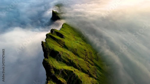 Witness the stunning cliffs of Drangarnir rise from the swirling mist in the Faroe Islands.