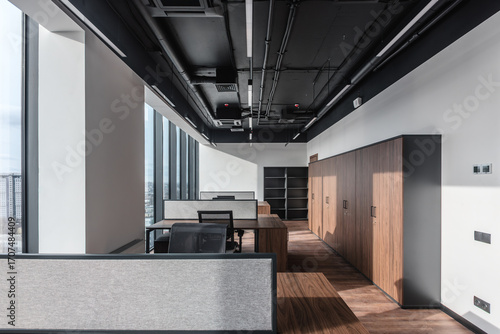 Part of ordinary office room decorated in modern style. Executive office with wooden desk and panoramic cityscape window