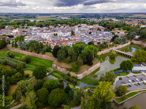 High angle aerial photo of the star-shaped fortifications and historic town center of Le Quesnoy, surrounded by green ramparts and water.