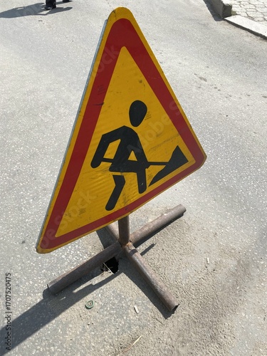 There is a road work ahead and a warning sign on the road