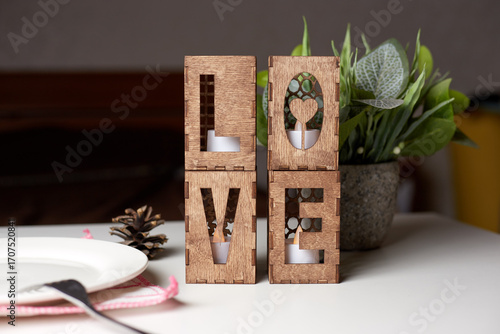 Wooden candlesticks in the form of the word Love.