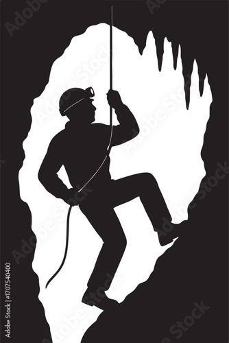 Silhouette of person rappelling down cave wall spelunking