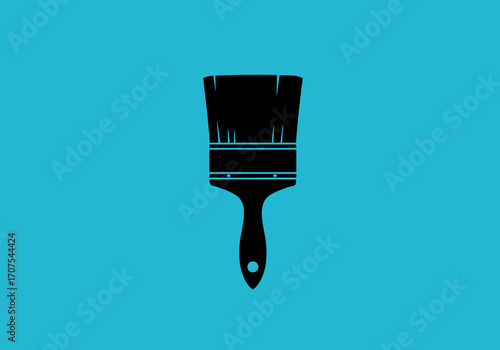 Black paint brush with worn bristles against a cyan backdrop