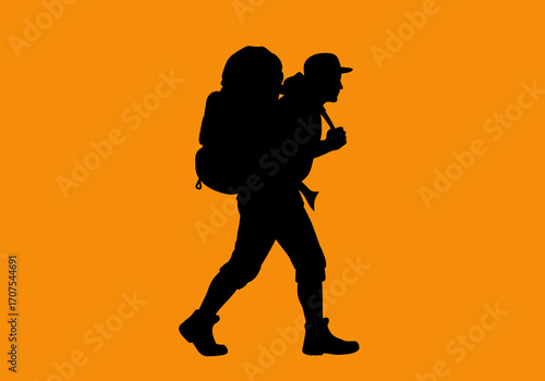 Black silhouette of hiker with backpack walking against a plain orange background
