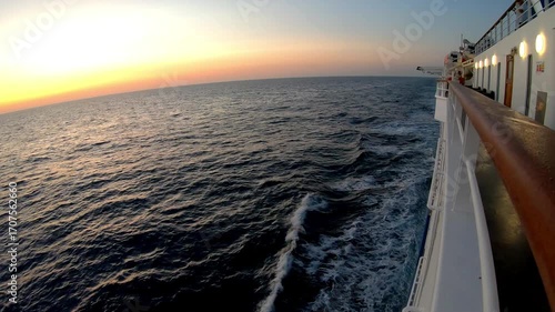 Scenic ocean view from cruise ship, showcasing the tranquil waves and vibrant sunset colors, as the vessel glides smoothly across the water, capturing the essence of maritime travel
