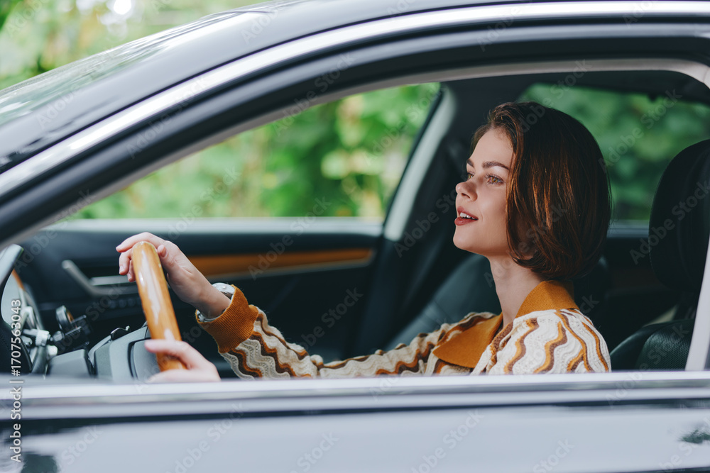 Naklejka premium A woman sits behind the steering wheel of a car, focused on the road with a calm expression, casual sweater and natural light highlighting the interior.