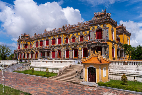 Canvas Print The magnificent, recently restored Kien Trung Palace in Hue, showcasing a vibrant yellow facade, striking red windows, and highly intricate architectural details under a cloudy sky