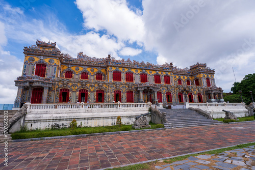 Wallpaper Mural A beautifully restored Kien Trung Palace in Hue, with its vibrant yellow facade, striking red windows, and elaborate rooftop decorations under a cloudy sky. Torontodigital.ca
