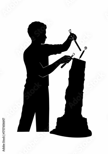 A silhouette artist engrossed in the creation of stone sculpture.