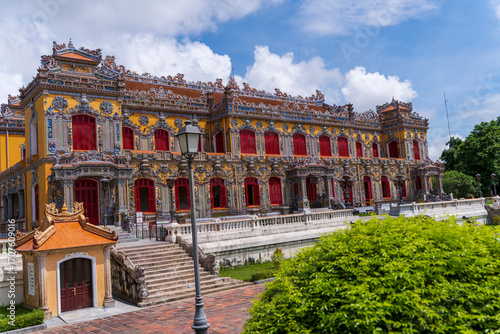 Wallpaper Mural The magnificent, recently restored Kien Trung Palace in Hue, showcasing a vibrant yellow facade, striking red windows, and highly intricate architectural details under a cloudy sky. Torontodigital.ca