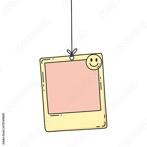 A cheerful, blank, hanging polaroid photo frame with a smiley face.