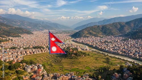 Iconic nepal national flag waving prominently over the famous kathmandu valley cityscape and majestic snow capped himalayan mountains