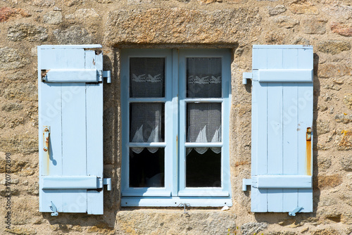 Blue window shutters on a house, Brittany, France
