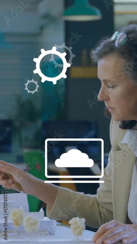 Animation of multiple digital icons against man working on his plan at office