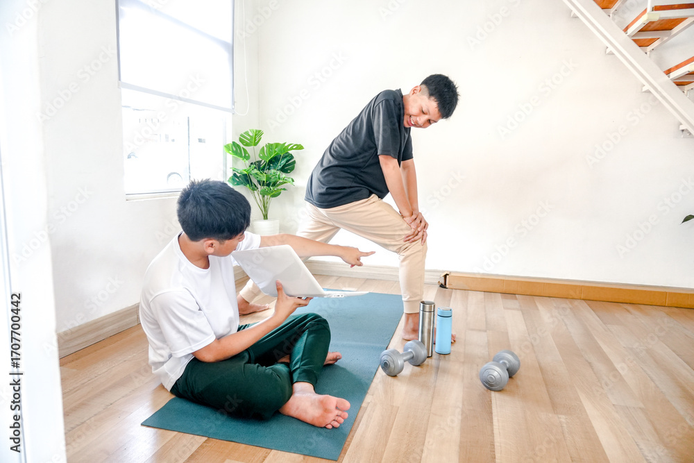 Obraz premium Two Cheerful Boys Laughter And Laptop During Fun Home Workout Session With Dumbbells Nearby
