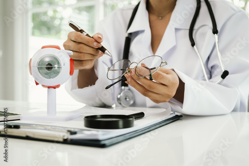 Obraz na plátne A doctor uses a magnifying glass with an anatomical eye model, demonstrating vision care, diagnosis, eye health, and medical education