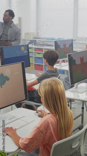 Elementary School Children Using Computers, Creating Digital Illustrations. African American Teacher Teaching Young Boys and Girls During Art Lesson Using Digital Screen. STEM Education. Vertical Shot