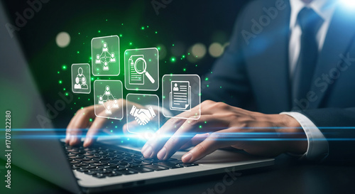 Businessman typing on a laptop with digital icons representing human resources, recruitment, and business strategy floating above the keyboard