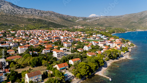 Fototapeta Naklejka Na Ścianę i Meble -  A small town with a beach and a mountain in the background