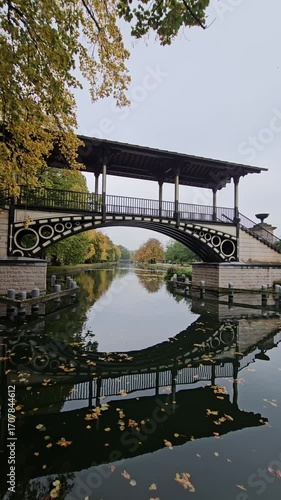 Historic Pont Napoleon bridge crossing the Moyenne - Deûle river with autumn trees in Lille, France
