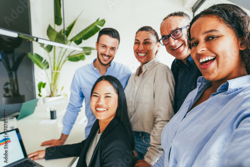 Multigenerational business people doing selfie inside company office - Multiracial colleagues having fun together - Job relationship and corporate concept - Main focus on right girl face
